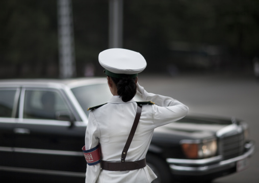 North Korean female traffic security officer saluting a mercedes in the street, Pyongan Province, Pyongyang, North Korea