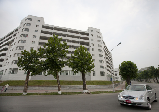 Mercedes on the road passing in front of luxury apartment block, Pyongan Province, Pyongyang, North Korea