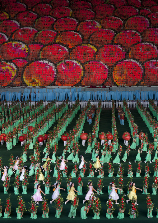 Women dancing in front of apples made by children pixels holding up boards during Arirang mass games in may day stadium, Pyongan Province, Pyongyang, North Korea