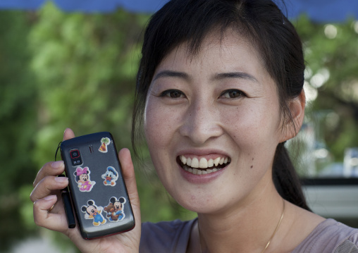 North Korean woman with disney characters stickers on her mobile phone, North Hwanghae Province, Pyongyang, North Korea