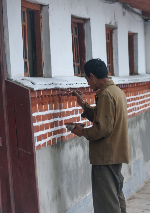 North Korean man painting a house in the old town, North Hwanghae Province, Kaesong, North Korea