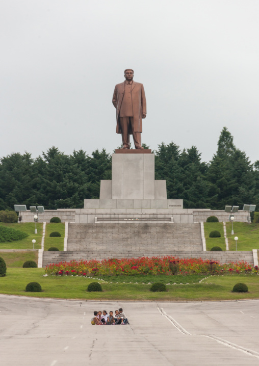 North Korean children sit in front of Dear leader Kim il Sung statue, North Hwanghae Province, Kaesong, North Korea