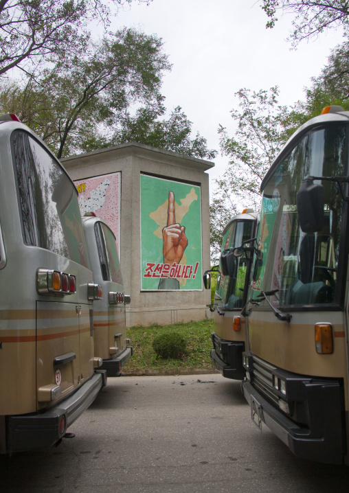 North Korean buses for tourists parked with reunification poster in background on the Demilitarized Zone, North Hwanghae Province, Panmunjom, North Korea