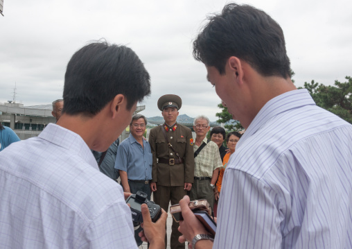 Tourists taking photos with a North Korean soldier on the Demilitarized Zone, North Hwanghae Province, Panmunjom, North Korea
