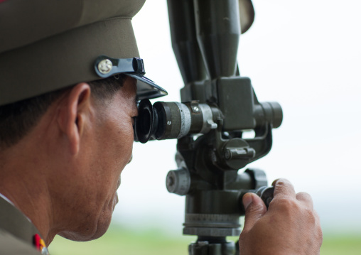 North Korean officer looking south Korea with binoculars at the Demilitarized Zone, North Hwanghae Province, Panmunjom, North Korea