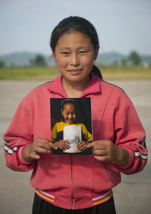 North Korean girl holding a picture of her taken two years before, South Pyongan Province, Chonsam Cooperative Farm, North Korea