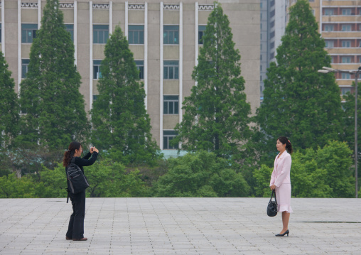 North Korean woman taking a picture of a friend, Pyongan Province, Pyongyang, North Korea