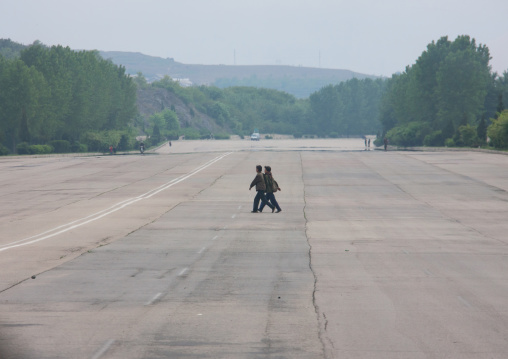 North Korean women crossing an empty highway, Pyongan Province, Pyongyang, North Korea