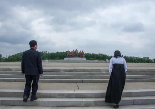 North Korean guides in front of a Kim il Sung statue, South Pyongan Province, Chongsan-ri Cooperative Farm, North Korea