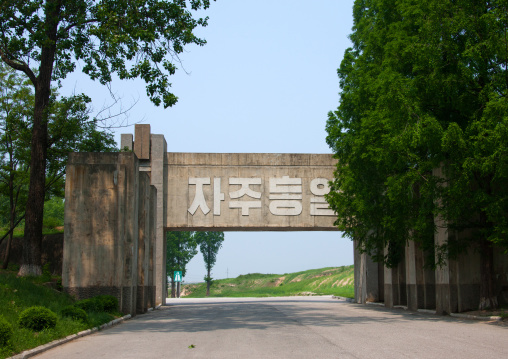 North Korean anti tank invasion concrete blocks on the roadside on the Demilitarized Zone with the slogan independent reunification, North Hwanghae Province, Panmunjom, North Korea