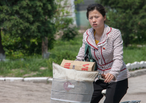 Portrait of a North Korean woman riding a bicycle, North Hwanghae Province, Kaesong, North Korea