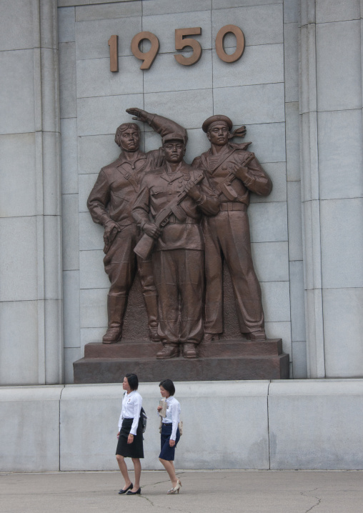 North Korean young women passing in front the arch of trimuph soliders statue, Pyongan Province, Pyongyang, North Korea
