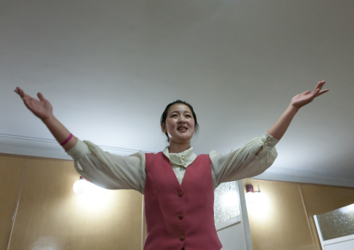 North Korean waitress in a restaurant singing for the tourists, Pyongan Province, Pyongyang, North Korea