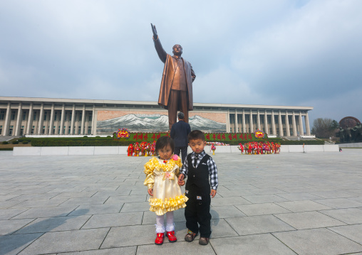 Two North Korean children in front of Kim il Sung statue in the Grand monument on Mansu hill, Pyongan Province, Pyongyang, North Korea