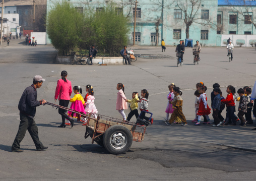 North Korean children crossing a road with their teacher, South Pyongan Province, Nampo, North Korea
