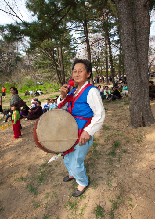 North Korean woman playing drum in a park for the day of the sun which is the birth anniversary of Kim Il-sung, Pyongan Province, Pyongyang, North Korea