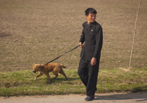 North Korean man holding a dog on leash, Kangwon Province, Wonsan, North Korea