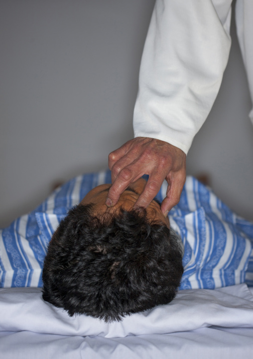 North Korean doctor making a massage on the head of a male patient, Pyongan Province, Pyongyang, North Korea