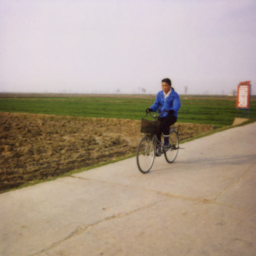 Polaroid of a North Korean girl riding a bicycle in the countryside, North Hwanghae Province, Kaesong, North Korea