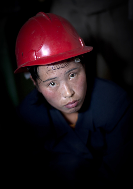 North Korean worker woman wearing a red helmet in a factory, South Pyongan Province, Nampo, North Korea