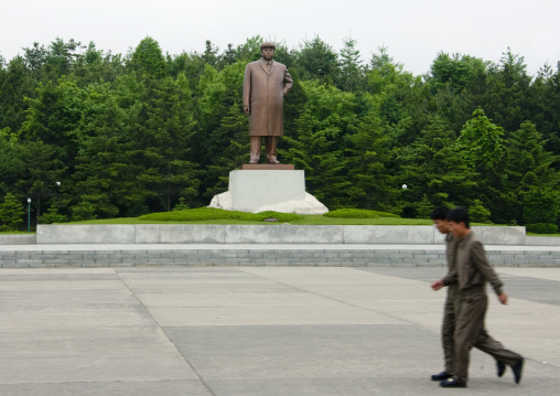 Two North Korean men passing by Kim il Sung statue, South Pyongan Province, Nampo, North Korea