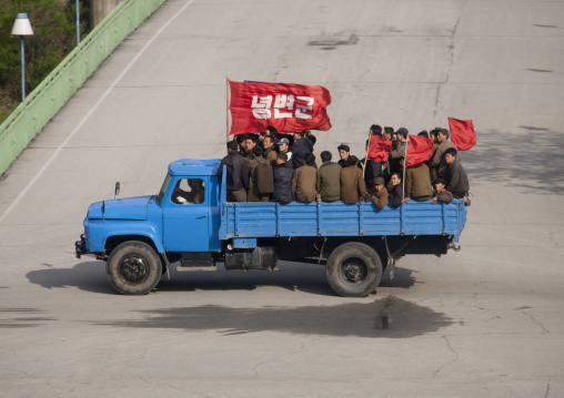 North Korean workers on a truck with red flags going to work, North Pyongan Province, Myohyang-san, North Korea