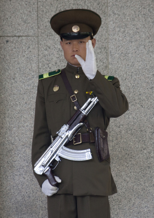 North Korean guard with a silver kalashnikov at the entrance of the international friendship exhibition warning the photographer, North Pyongan Province, Myohyang-san, North Korea