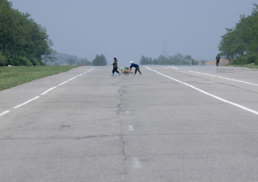 North Korean women crossing an empty highway, Pyongan Province, Pyongyang, North Korea