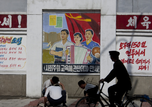 North Korean people in front of propaganda billboard in the street, Pyongan Province, Pyongyang, North Korea