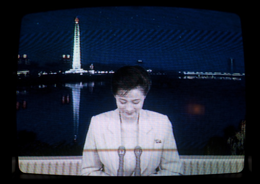 North Korean television news presenter with the Juche tower in the background, Pyongan Province, Pyongyang, North Korea