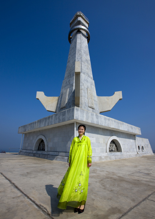North Korean woman in choson-ot standing in front of a lighthouse, South Pyongan Province, Nampo, North Korea