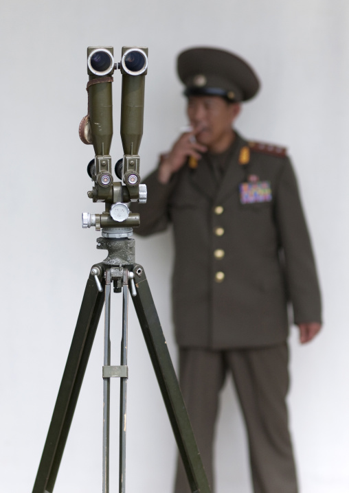 North Korean officer smoking near binoculars on the Demilitarized Zone, North Hwanghae Province, Panmunjom, North Korea
