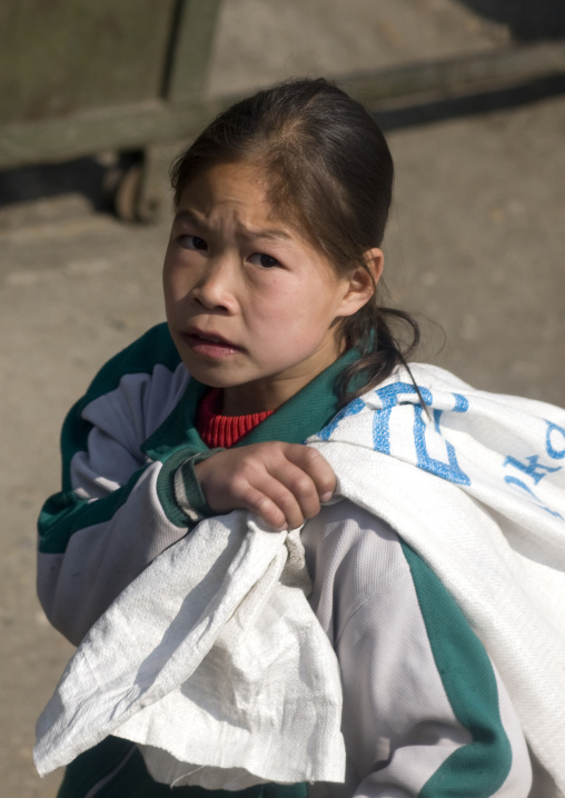 North Korean girl carrying a heavy bag, South Pyongan Province, Nampo, North Korea