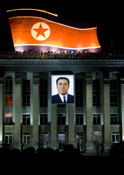 Kim il Sung square at night with a North Korean flag and a portrait of Kim il Sung, Pyongan Province, Pyongyang, North Korea