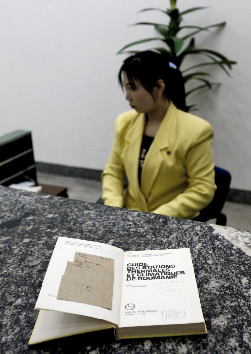 North Korean employee showing a book about spas in romania in the Grand people's study house, Pyongan Province, Pyongyang, North Korea