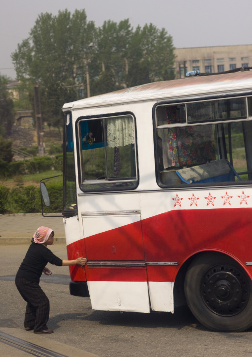 North Korean woman cleaning a public bus with red stars one star represents 50000 km of safe driving, Pyongan Province, Pyongyang, North Korea