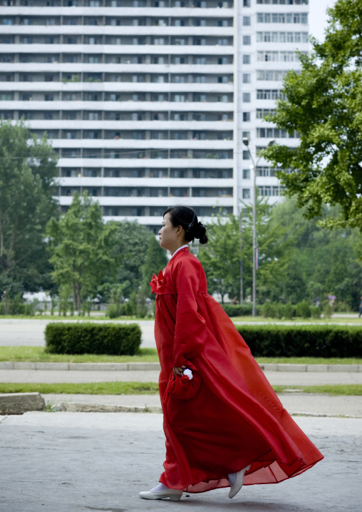 North Korean woman in traditional red choson-ot in the street, Pyongan Province, Pyongyang, North Korea