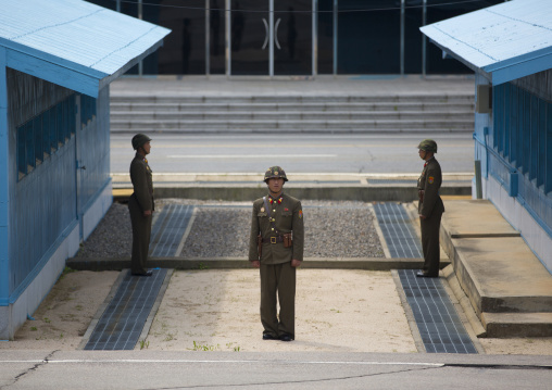 Three North Korean soldiers standing in front of the United Nations conference rooms on the demarcation line in the Demilitarized Zone, North Hwanghae Province, Panmunjom, North Korea