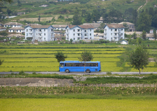Blue bus passing in the countryside, North Hwanghae Province, Kaesong, North Korea