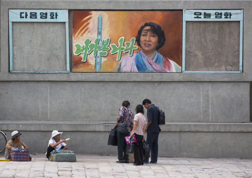 North Korean people byuing ice creams in the street under a movie poster, North Hwanghae Province, Kaesong, North Korea