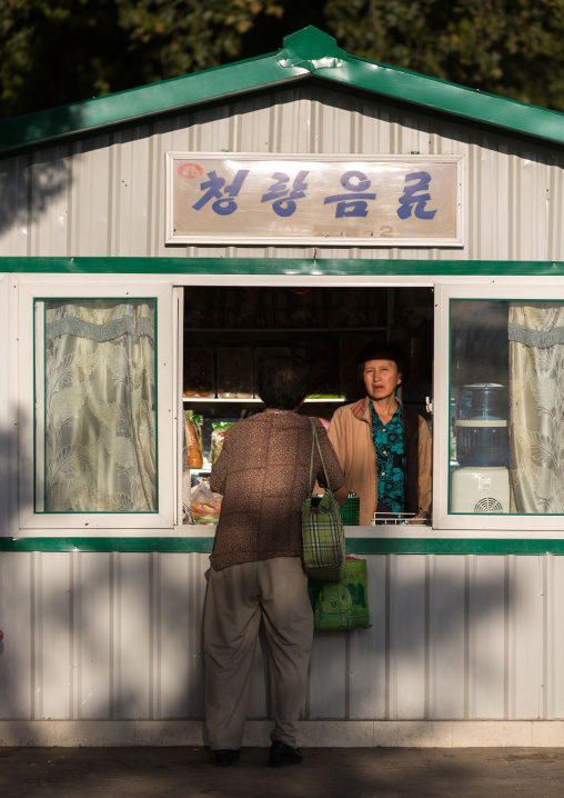 North Korean woman buying fresh drinks in a small shop, Pyongan Province, Pyongyang, North Korea