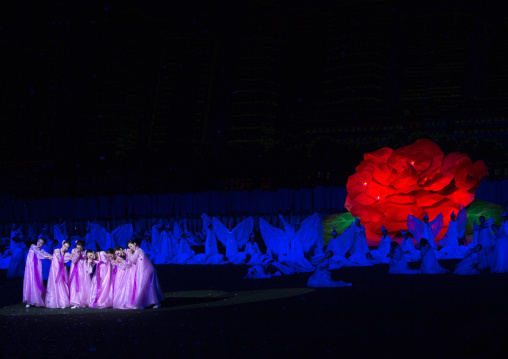 North Korean women dancing in front of a giant Kimilsungia flower during the Arirang mass games in may day stadium, Pyongan Province, Pyongyang, North Korea