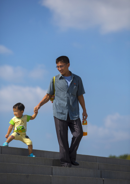 North Korean father and child on the stairs of the Juche tower, Pyongan Province, Pyongyang, North Korea