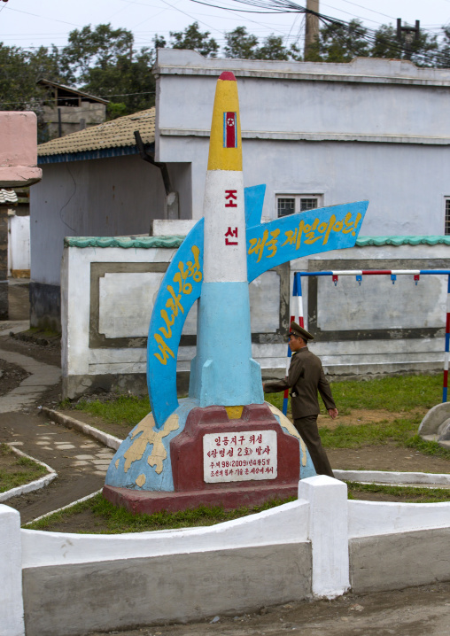 North Korean soldier passing in front of a missile monument inside a school visited by the Dear Leaders, South Hamgyong Province, Hamhung, North Korea