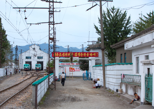 Train station and garage in a village with the slogan long live general Kim jong-un, The sun of songun joseon, South Hamgyong Province, Hamhung, North Korea