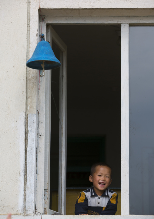 Smiling North Korean child boy in the window of a school, South Hamgyong Province, Hamhung, North Korea
