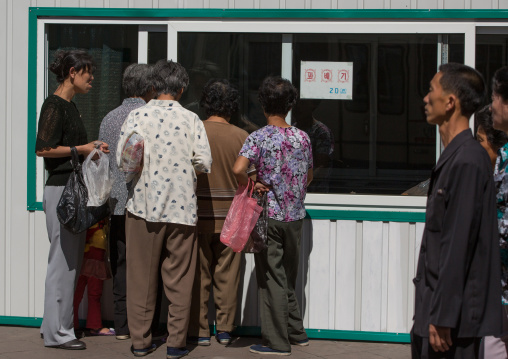 North Korean people queueing to buy some food in a shop in the street, Pyongan Province, Pyongyang, North Korea