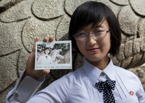North Korean young woman showing a polaroid of herself, Pyongan Province, Pyongyang, North Korea