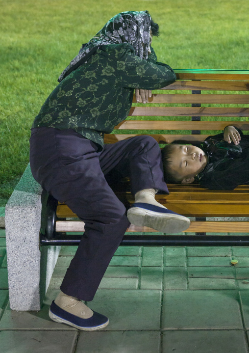 North Korean mother and her son sleeping on a bench in a park at night, Pyongan Province, Pyongyang, North Korea