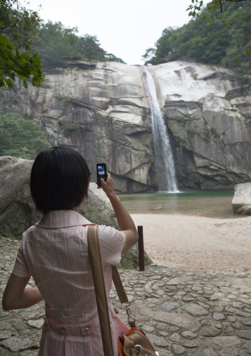 North Korean woman taking picture of pakyon falls, North Hwanghae Province, Kaesong, North Korea